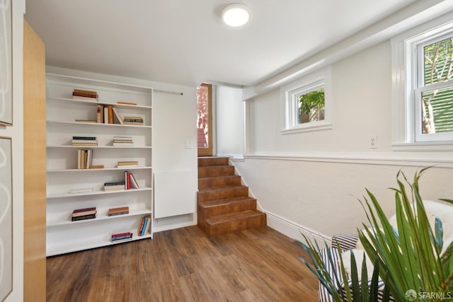 living area with stairway and wood finished floors