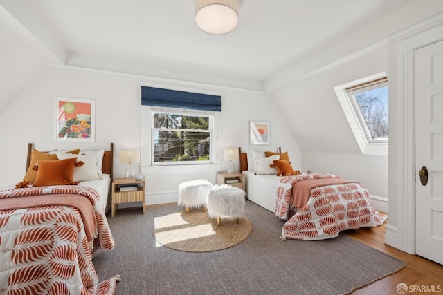 bedroom with baseboards, multiple windows, and vaulted ceiling with skylight