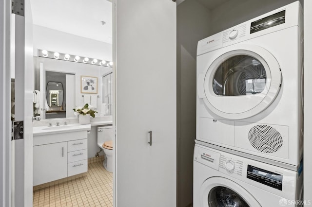 clothes washing area with light tile patterned flooring, sink, and stacked washer and clothes dryer