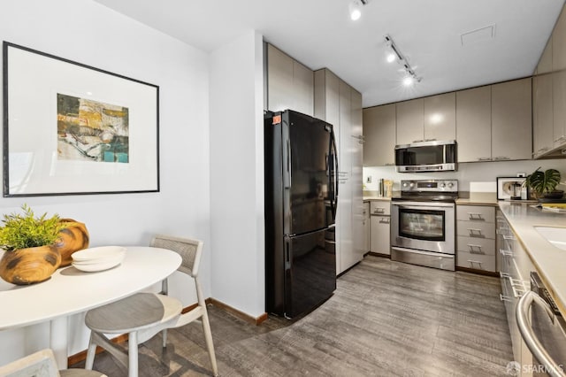 kitchen with dark hardwood / wood-style flooring, stainless steel appliances, and gray cabinetry