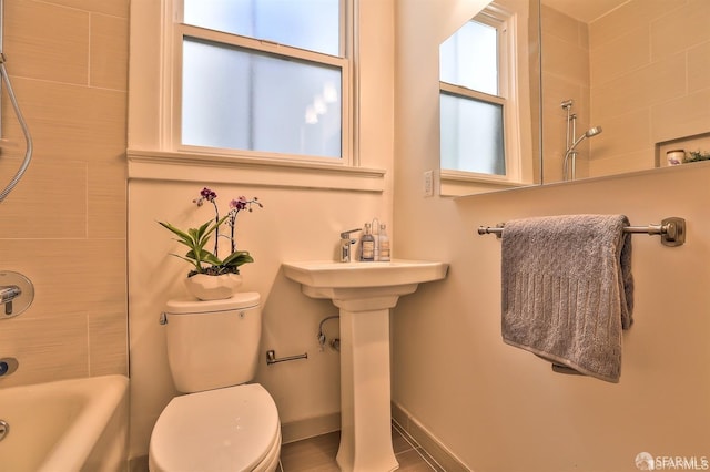 bathroom with tiled shower / bath and toilet