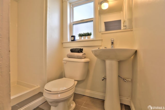 bathroom featuring a shower and toilet