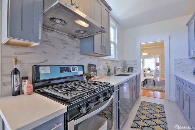 kitchen with tasteful backsplash, sink, a notable chandelier, appliances with stainless steel finishes, and light tile patterned floors