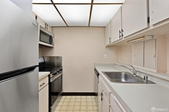 kitchen featuring appliances with stainless steel finishes, white cabinetry, and sink