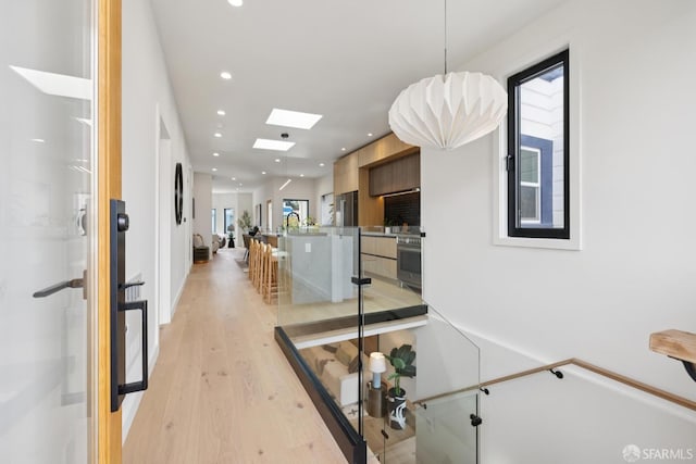 738 Athens St, San Francisco, CA 94112 - hallway featuring a skylight, light wood-type flooring, and recessed lighting