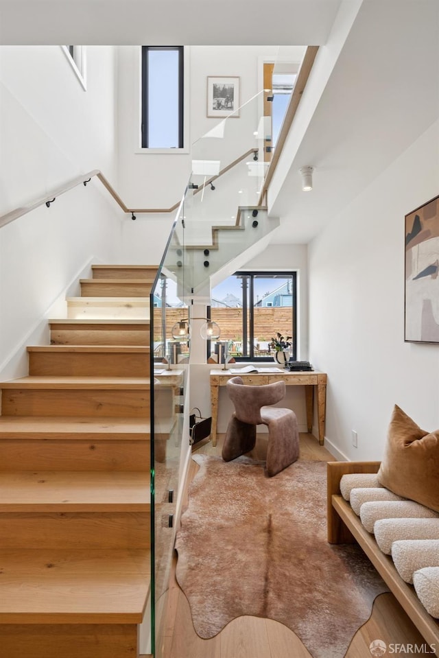 738 Athens St, San Francisco, CA 94112 - staircase featuring a towering ceiling and wood finished floors