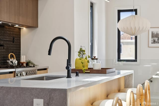 738 Athens St, San Francisco, CA 94112 - kitchen featuring modern cabinets, decorative backsplash, hanging light fixtures, and light stone countertops