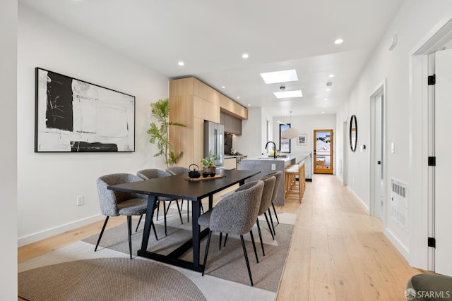 738 Athens St, San Francisco, CA 94112 - dining area with light wood-style floors, a skylight, and recessed lighting