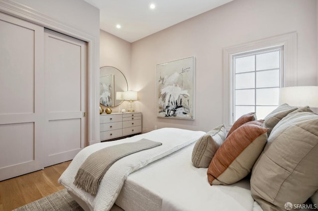 bedroom with a closet and light hardwood / wood-style flooring