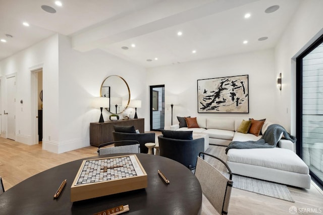 living room featuring beamed ceiling and light hardwood / wood-style floors