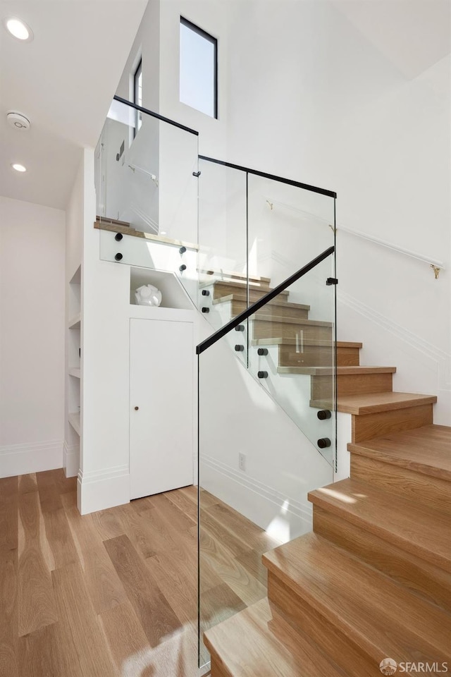 stairs featuring wood-type flooring and built in features