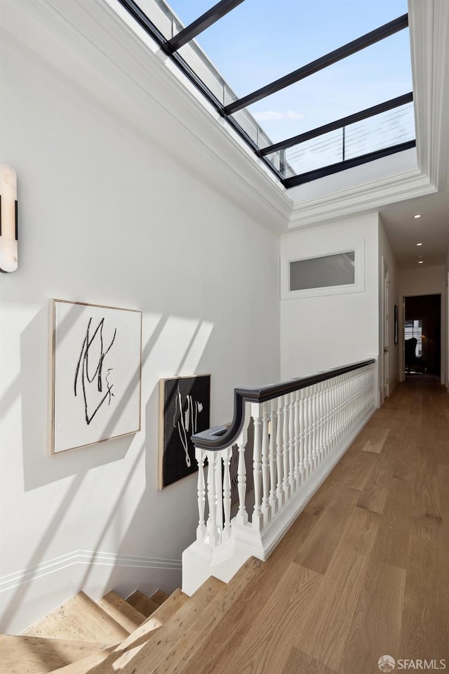 staircase with a skylight and wood-type flooring