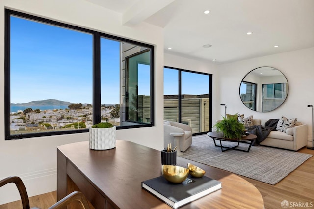 living room with a mountain view, hardwood / wood-style floors, and beamed ceiling