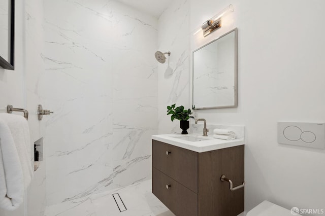 bathroom featuring a tile shower, toilet, and vanity