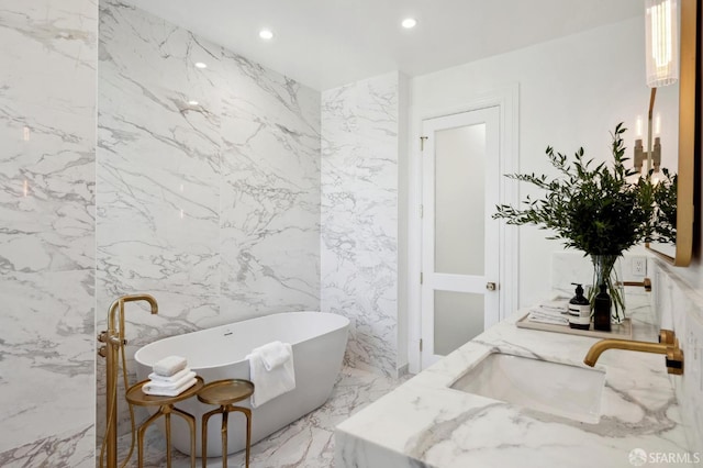 bathroom with a washtub, tile walls, and vanity