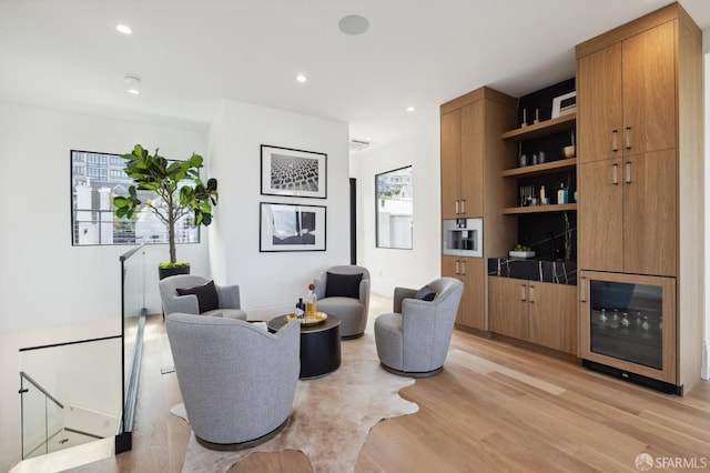 sitting room with light hardwood / wood-style floors and wine cooler