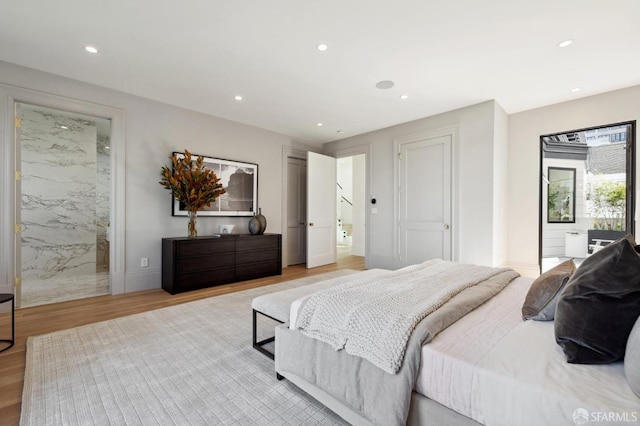 bedroom with light hardwood / wood-style floors and connected bathroom