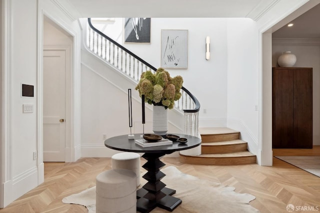 foyer with light parquet flooring and ornamental molding