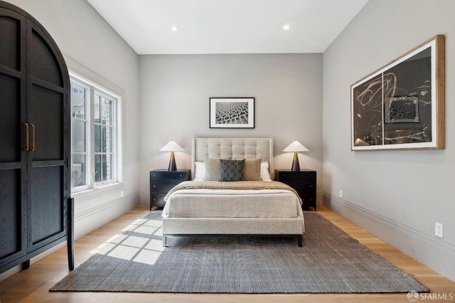 bedroom with multiple windows and light hardwood / wood-style flooring