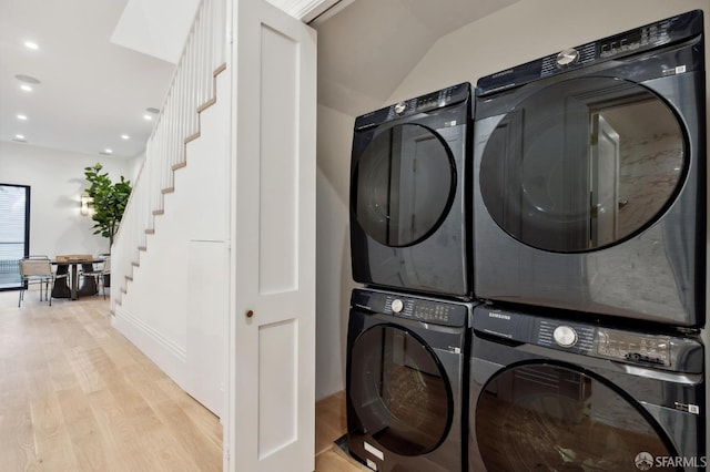 laundry area with light wood-type flooring and stacked washer and clothes dryer