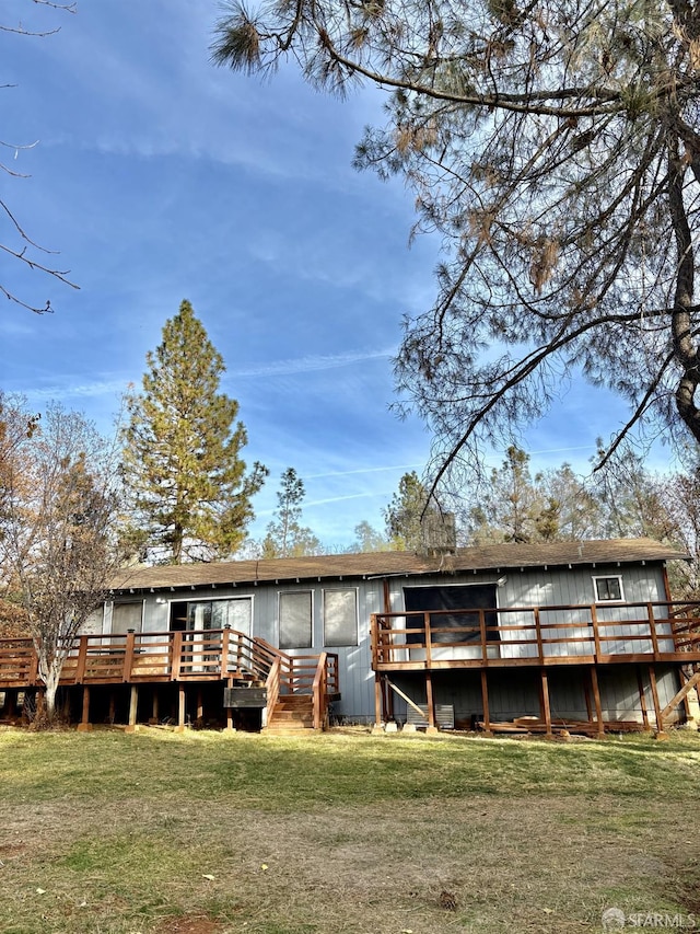 back of property with a lawn and a deck