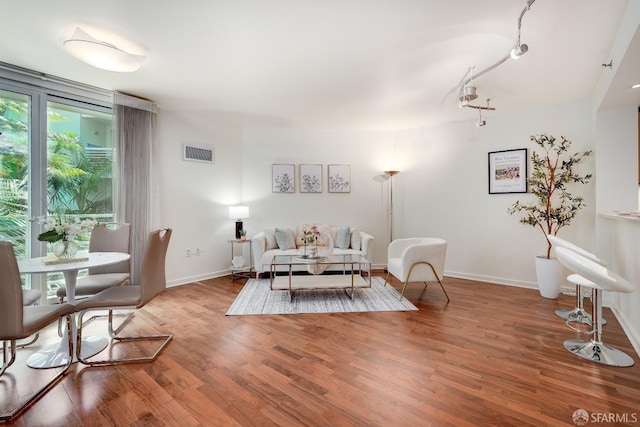 living area with visible vents, baseboards, and wood finished floors