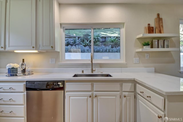 kitchen with light stone counters, dishwasher, sink, and white cabinets