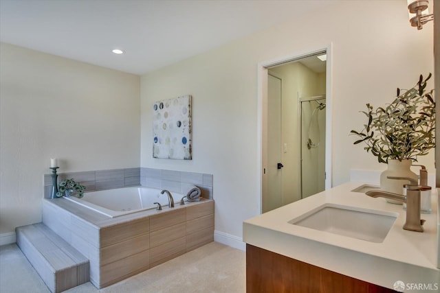 bathroom featuring vanity and independent shower and bath