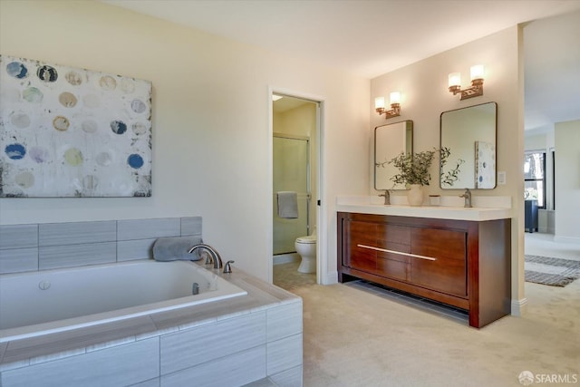 bathroom featuring vanity, toilet, and tiled bath