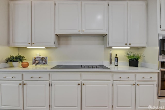 kitchen with black electric stovetop and white cabinets