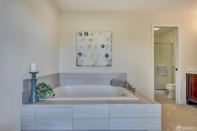 bathroom featuring vanity, toilet, and tiled bath