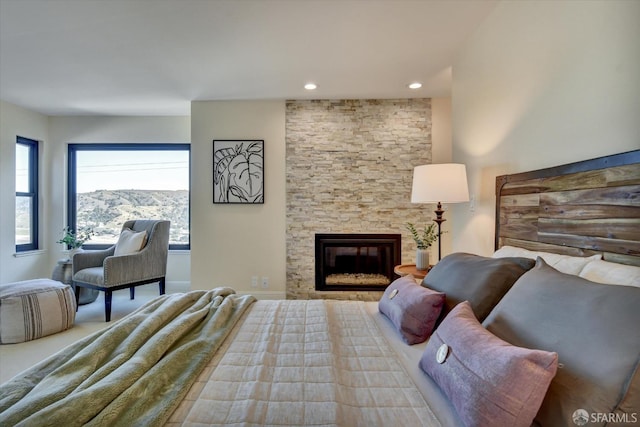 bedroom featuring a stone fireplace and a mountain view