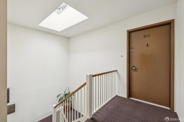 corridor featuring carpet floors and a skylight