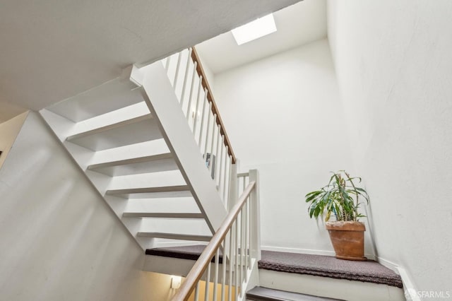 stairway featuring a skylight