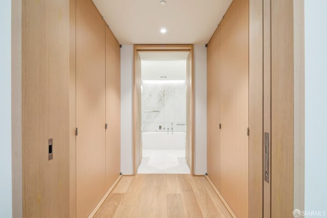 corridor with light hardwood / wood-style floors