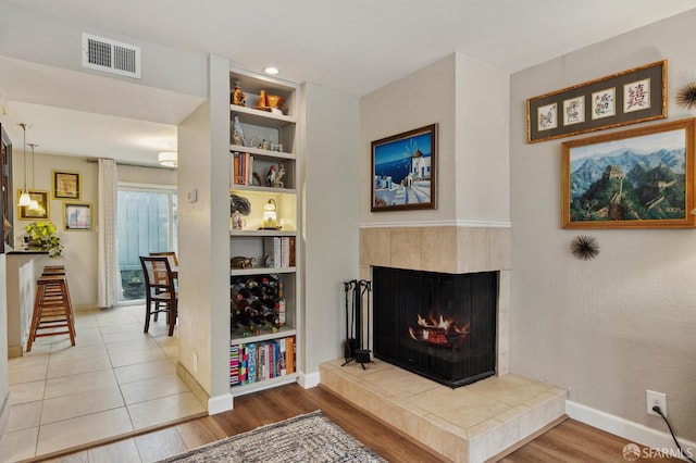 1421 El Camino Real Unit 3, Burlingame, CA 94010 - living room with wood finished floors, a tiled fireplace, baseboards, and built in features