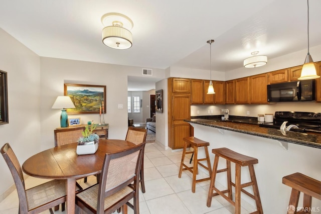 1421 El Camino Real Unit 3, Burlingame, CA 94010 - kitchen with black appliances, a kitchen bar, brown cabinets, light tile patterned floors, and pendant lighting
