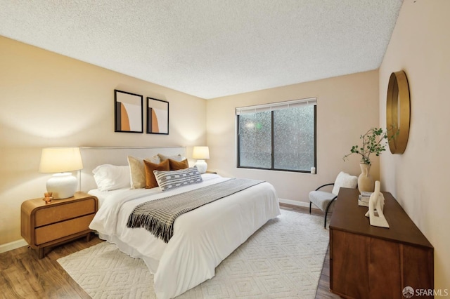 bedroom featuring light hardwood / wood-style floors and a textured ceiling