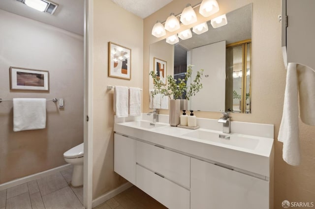 bathroom with toilet, a textured ceiling, and vanity