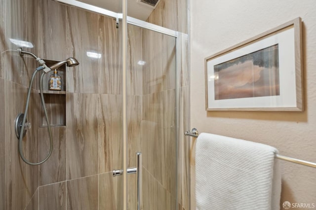 bathroom featuring a shower with door