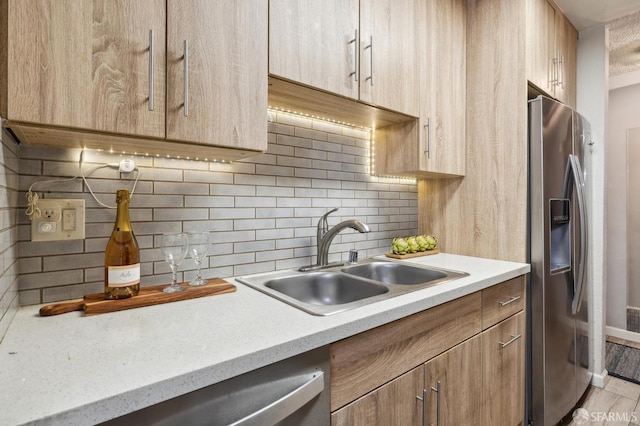 kitchen featuring decorative backsplash, sink, and stainless steel fridge with ice dispenser