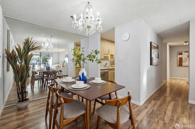 dining space featuring a textured ceiling, dark hardwood / wood-style floors, and a notable chandelier