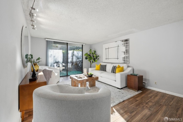 living room featuring a wall of windows, wood-type flooring, a textured ceiling, and rail lighting