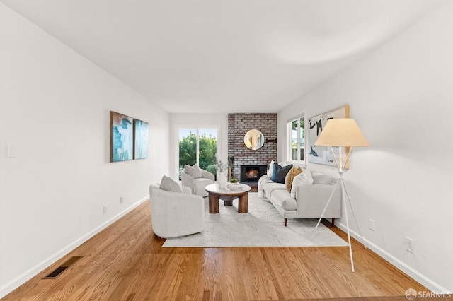 2811 Bayview Dr, Alameda, CA 94501 - living room featuring wood finished floors, a brick fireplace, and baseboards