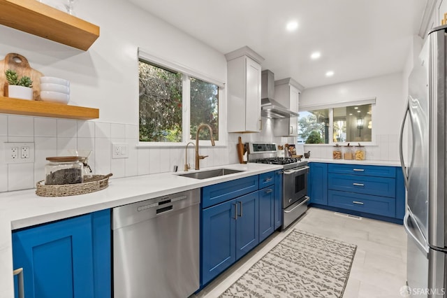 2811 Bayview Dr, Alameda, CA 94501 - kitchen featuring stainless steel appliances, a sink, open shelves, blue cabinetry, and wall chimney exhaust hood