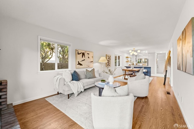 2811 Bayview Dr, Alameda, CA 94501 - living room featuring light wood-style flooring, a chandelier, and baseboards
