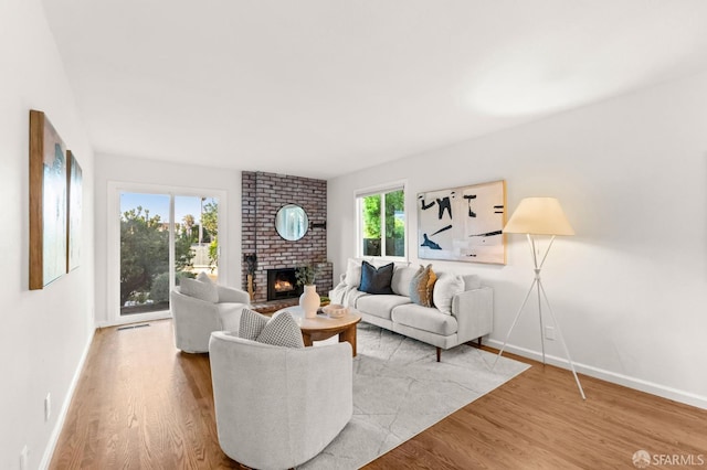 2811 Bayview Dr, Alameda, CA 94501 - living room featuring wood finished floors, a brick fireplace, and baseboards