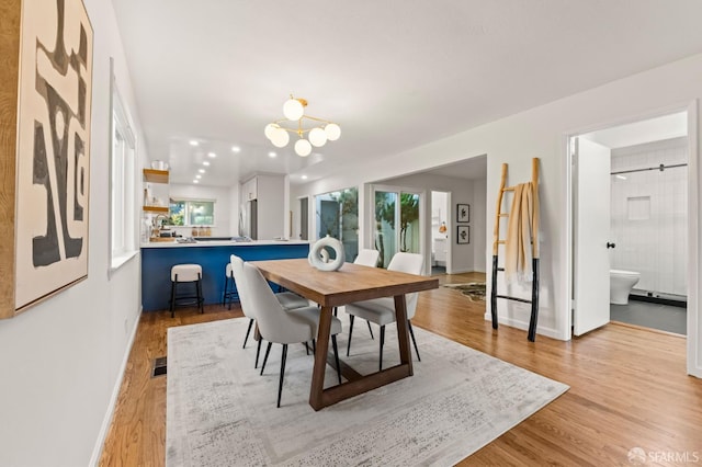 2811 Bayview Dr, Alameda, CA 94501 - dining room with light wood finished floors, a chandelier, and baseboards