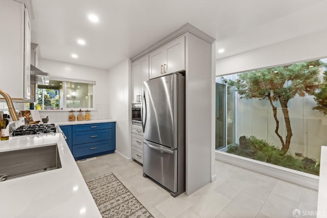 2811 Bayview Dr, Alameda, CA 94501 - kitchen with stainless steel appliances, light countertops, recessed lighting, blue cabinetry, and tasteful backsplash