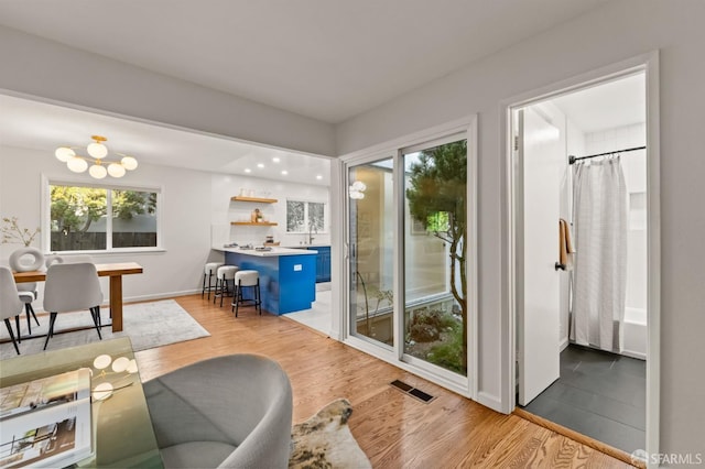 2811 Bayview Dr, Alameda, CA 94501 - living room with healthy amount of natural light, light wood finished floors, a chandelier, and baseboards